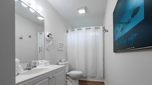 A bathroom with a white vanity, a hairdryer, a toilet, and a shower curtain. - Family Friendly 3BR Murrells Inlet - Moss Creek Unit 32 (Murrells Inlet)
