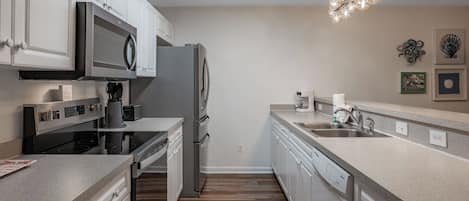A modern kitchen with stainless steel appliances, a built-in oven, and a dishwasher.