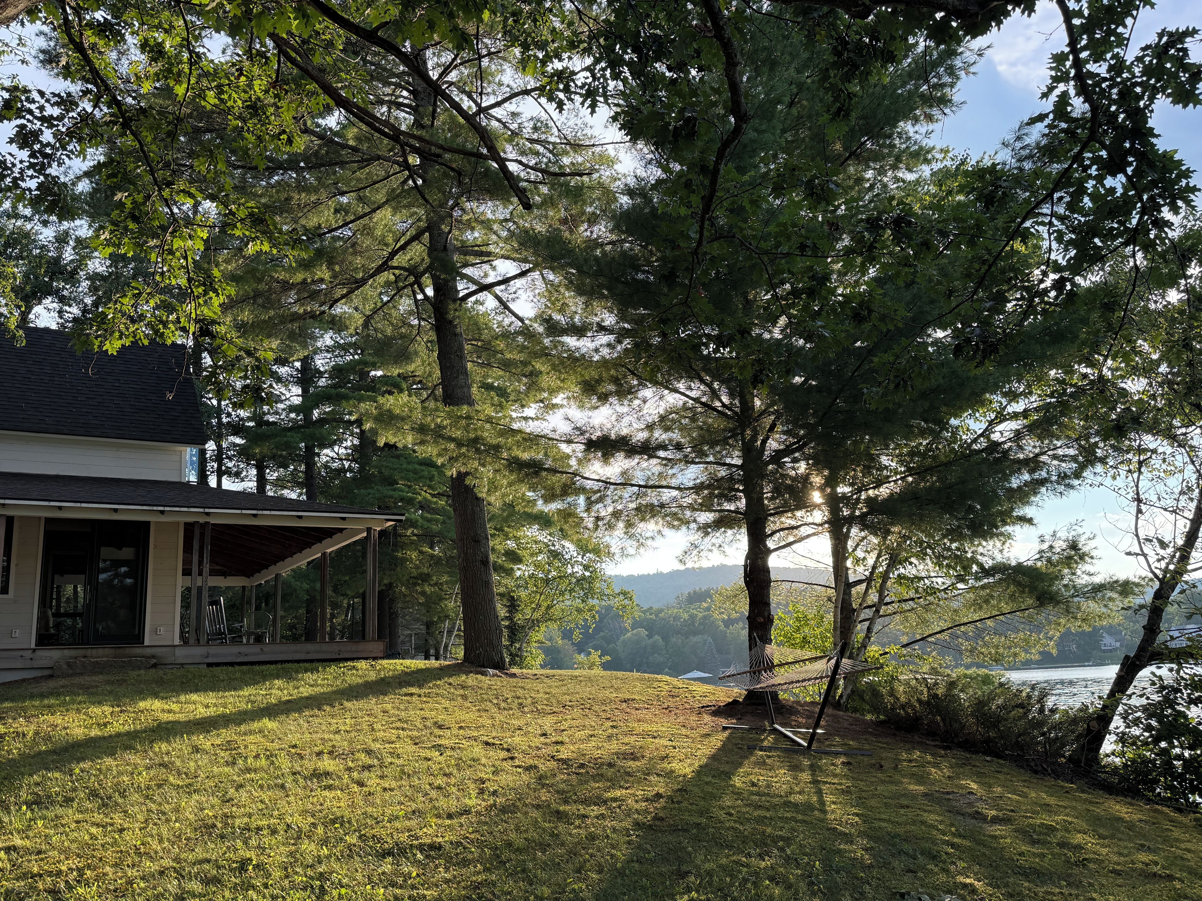 A house with a porch, a hammock, and a view of a lake.