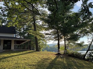 A house with a porch, a hammock, and a view of a lake.