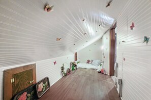A room with a sloped ceiling, wooden flooring, and butterfly wall decorations.