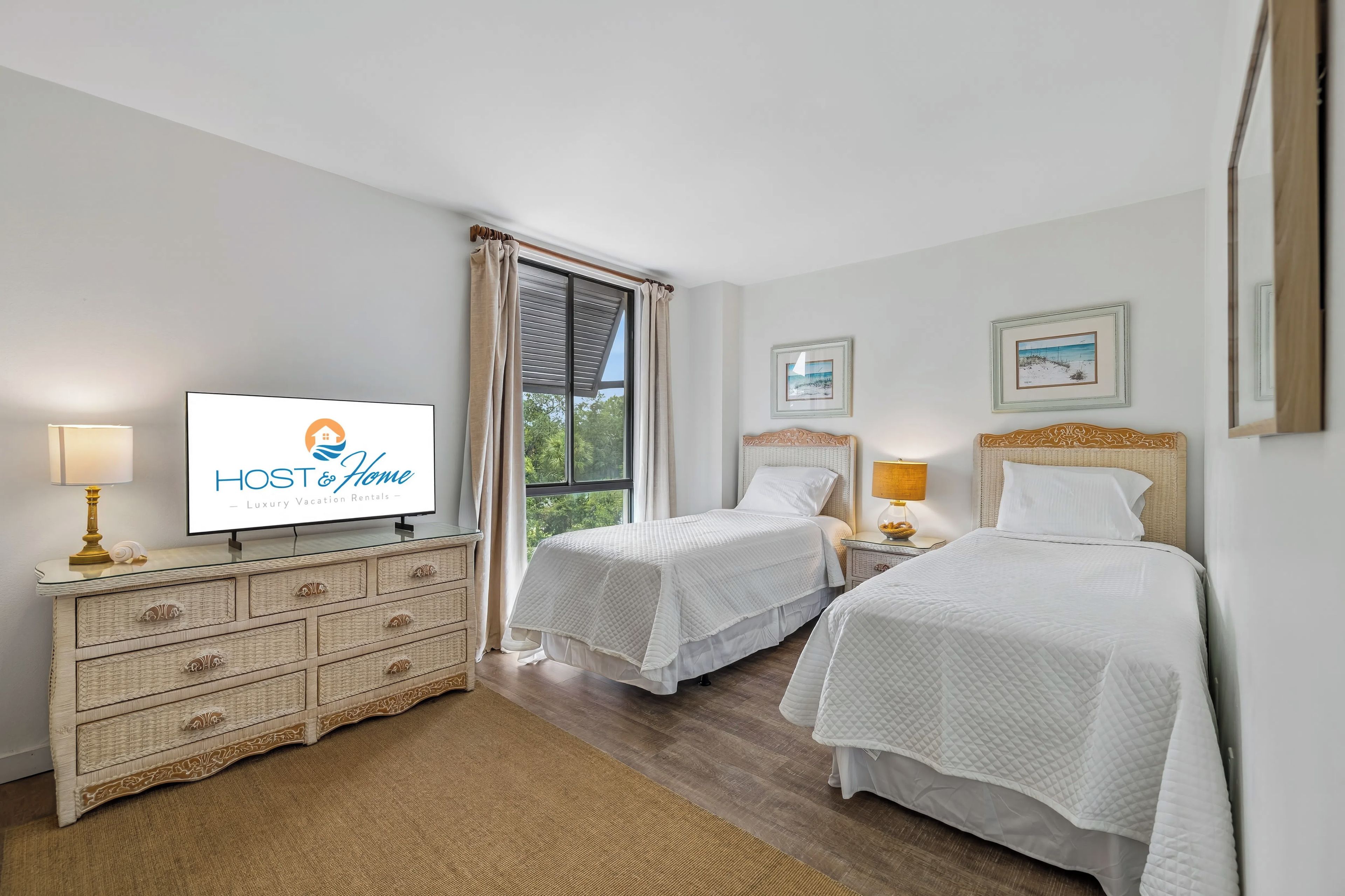 Habitación de hotel con dos camas, televisor, cómoda y ventana con cortinas.
