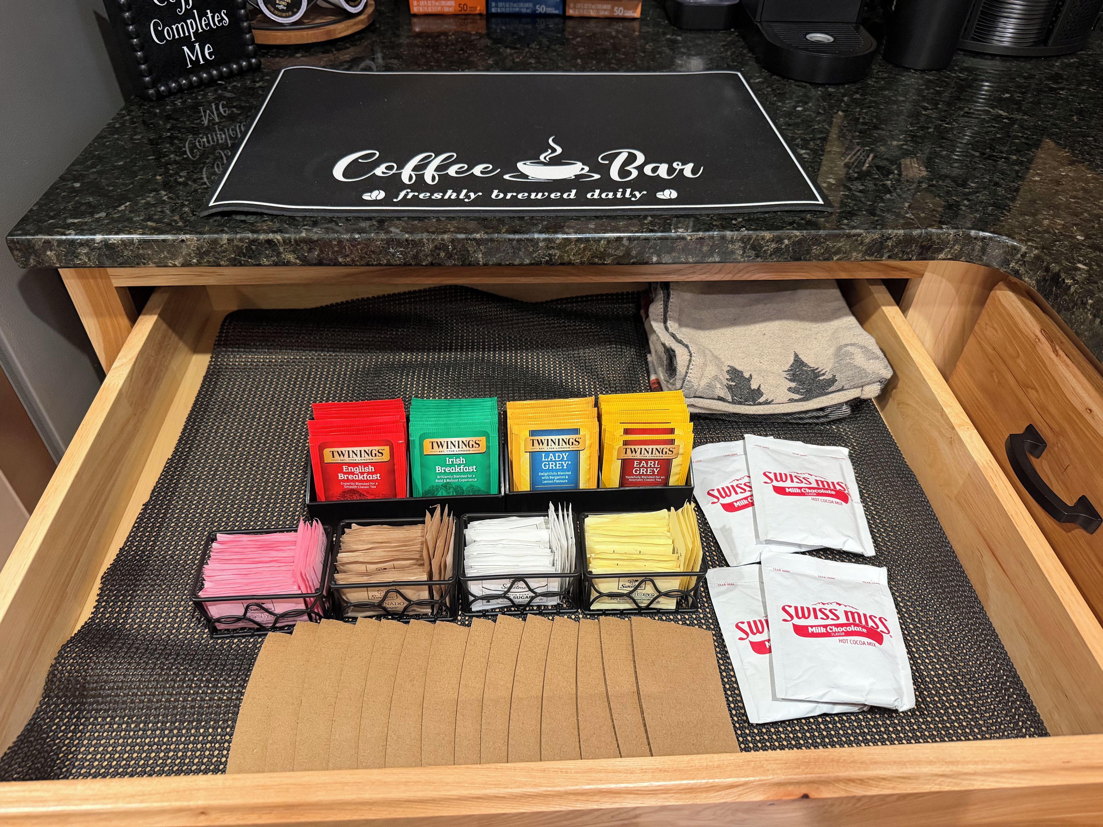 Un cajón con cápsulas de café, bolsitas de té e ingredientes de Swiss Miss.