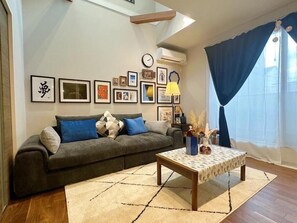 Una sala de estar con un sofá, una mesa de centro y una pared decorada con fotografías enmarcadas.