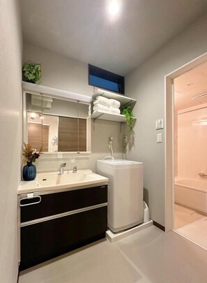 Un baño moderno con lavamanos doble, un espejo, toallero y zona de ducha.