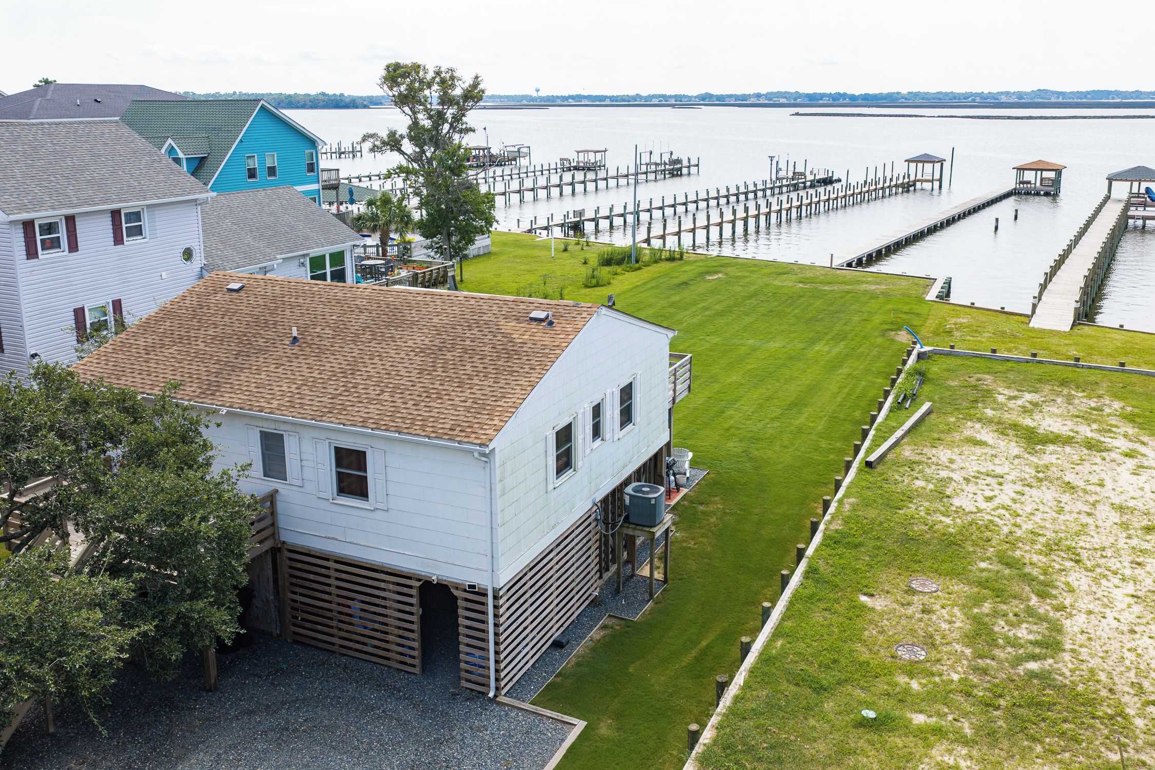 A residential area with a house, a dock, and a grassy yard.