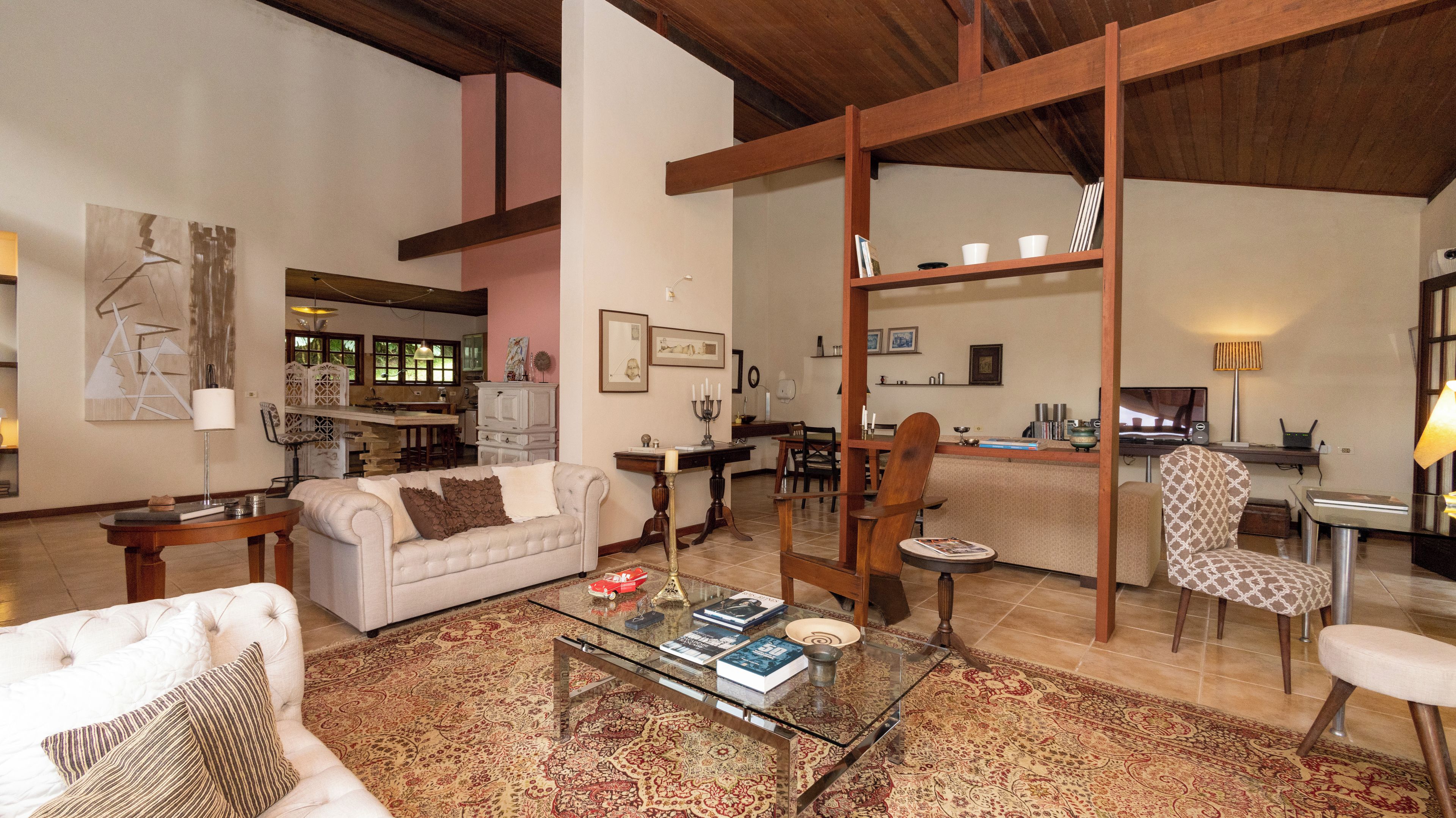 A spacious living area with a sofa, armchairs, a coffee table, and a dining area with chairs and a table.