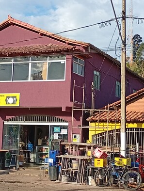 A two-story building with a red roof and a yellow signboard.