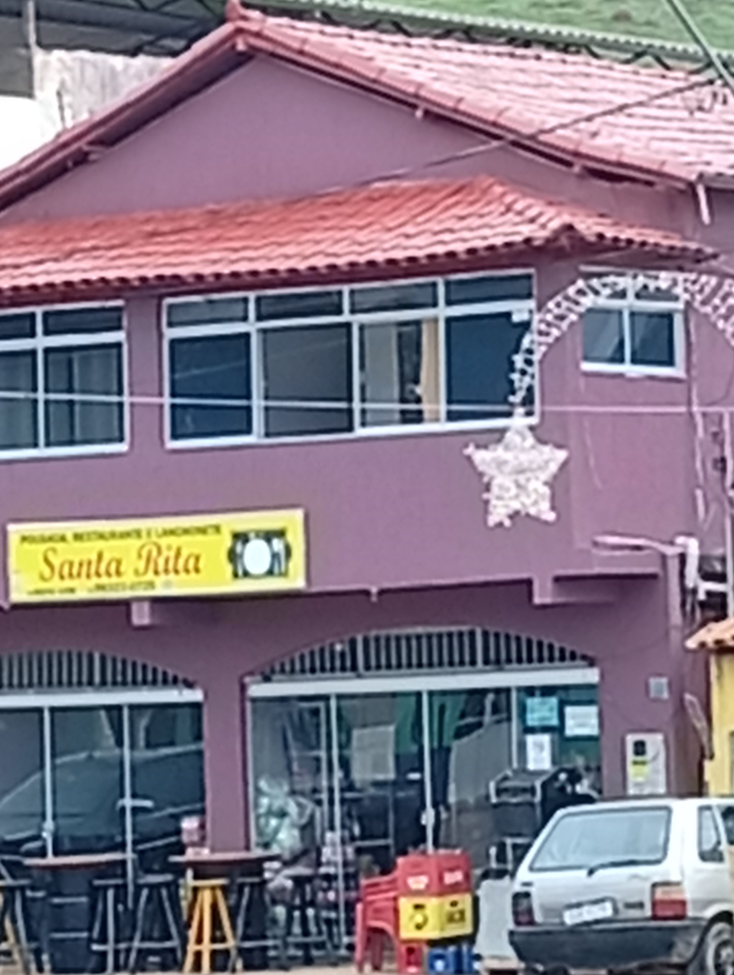 Un edifici amb un rètol que diu 'Santa Rita' i una zona d'estar a l'exterior coberta.