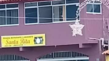 Un edifici amb un rètol que diu 'Santa Rita' i una zona d'estar a l'exterior coberta.