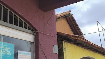 Un edifici amb una càmera de seguretat, una reixa i una finestra amb un rètol.