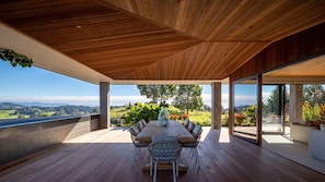 An outdoor dining area with a view of the countryside. - The Distiller's Retreat (Takaka)