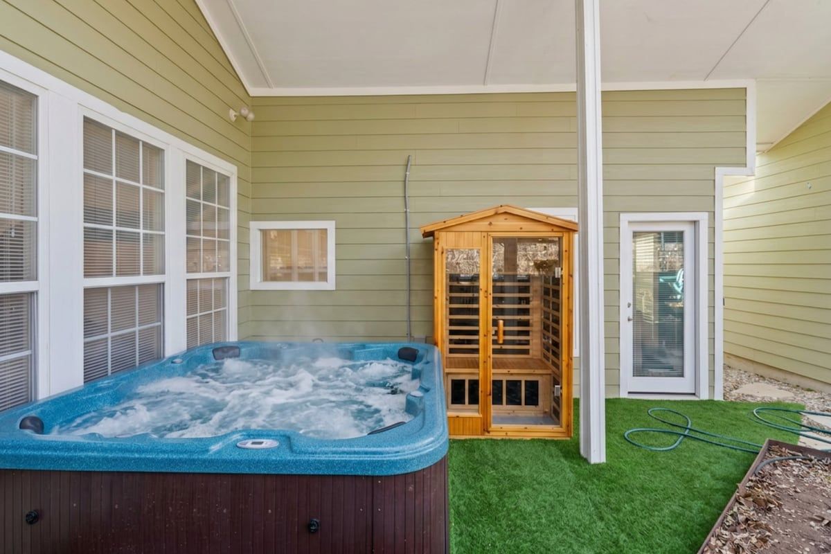 A hot tub in a covered outdoor area with a wooden structure and a door.