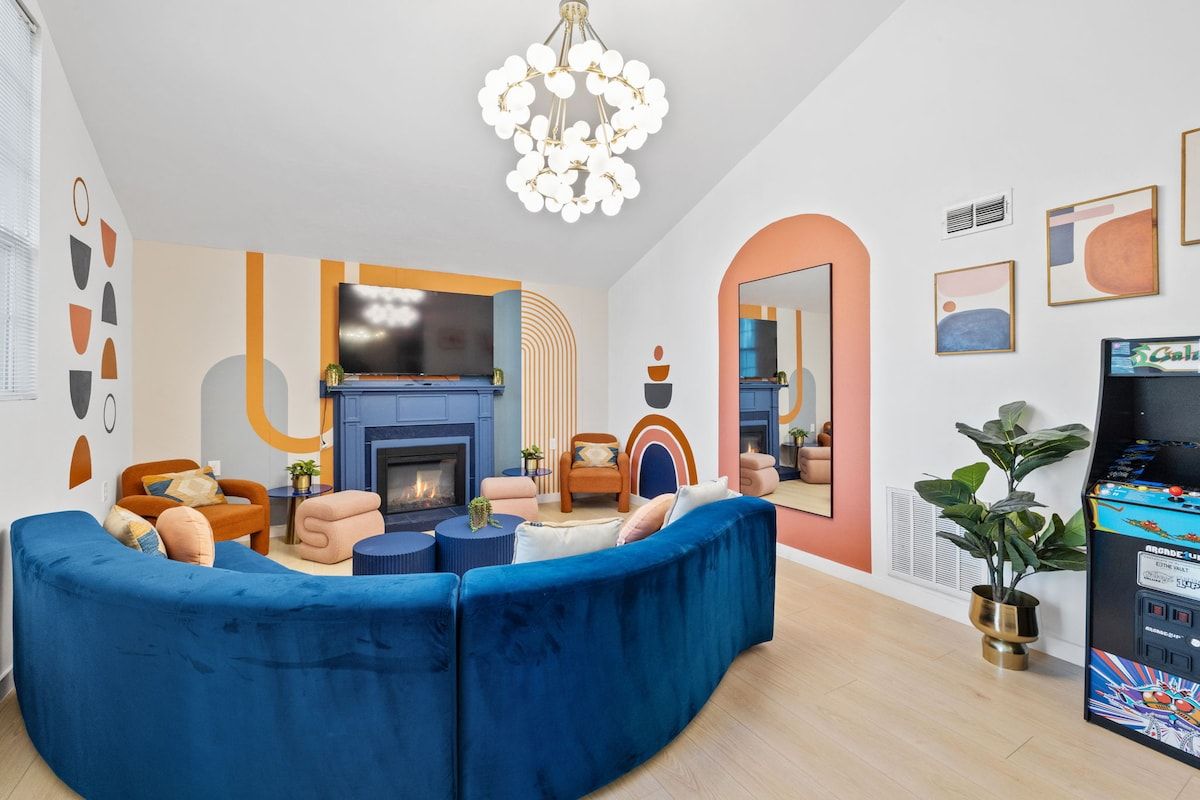 A modern living room with a blue sectional sofa, a fireplace, and a television.