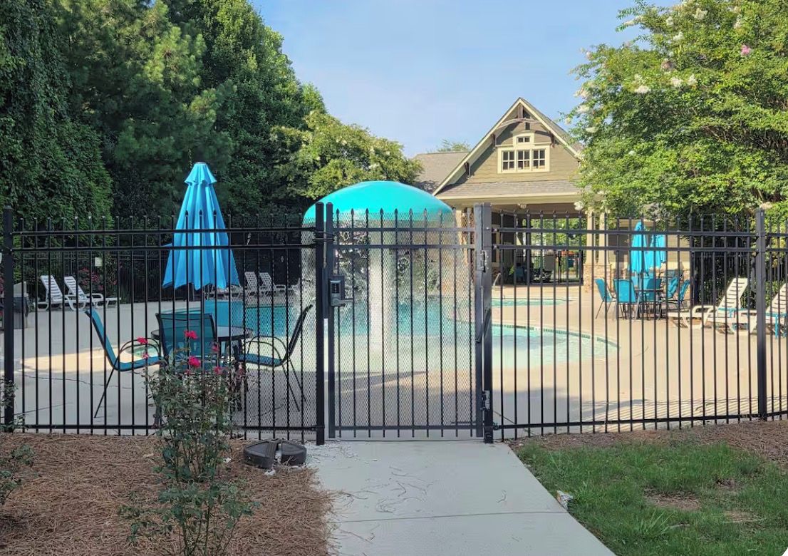 Une cour arrière clôturée avec une piscine, des chaises longues et un belvédère.