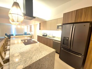 Eine moderne Küche mit Granitarbeitsplatte, Edelstahlgeräten und Holzschränken.