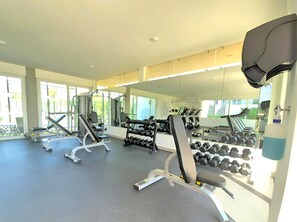 A gym with exercise equipment, large windows, and a mirror. - Spacious 3-bedroom Ocean View apartment Flamingos Nuevo Vallarta (Nuevo Vallarta)