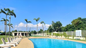 A swimming pool with lounge chairs, palm trees, and a fenced area. - Spacious 3-bedroom Ocean View apartment Flamingos Nuevo Vallarta (Nuevo Vallarta)