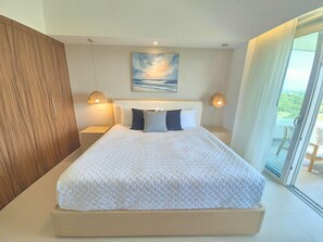 A modern bedroom with a large bed, two bedside lamps, a painting above the bed, and a view through a glass door. - Spacious 3-bedroom Ocean View apartment Flamingos Nuevo Vallarta (Nuevo Vallarta)