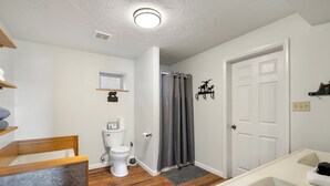 A bathroom with a toilet, sink, and shower area. - Log Cabin Retreat | Private Dock & Mountain Views (Anaconda)