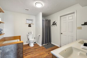 Un baño con inodoro, lavabo y zona de ducha.