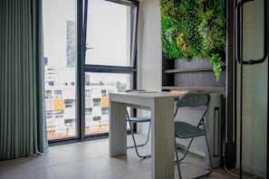 Ein modernes Zimmer mit großem Fenster, Schreibtisch und Stuhl.