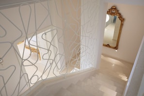 A staircase with a white abstract wall design, a gold-framed mirror, and a patterned carpet. - Villa Vitomera - Modern villa with pool (Primosten)