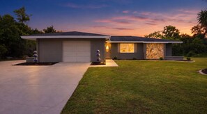 A modern two-story house with a garage, a well-maintained lawn, and a stone facade on one side. - Waterfront 2BR · Heated Saltwater Pool & Spa · Dock + 10K Boat Lift (Port Charlotte)