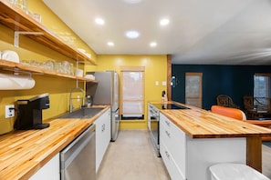 A compact kitchen with wooden countertops, a refrigerator, and a coffee machine. - Austin Cowboy Pool w/ Sauna - Pet Friendly - Fire Pit (Austin)