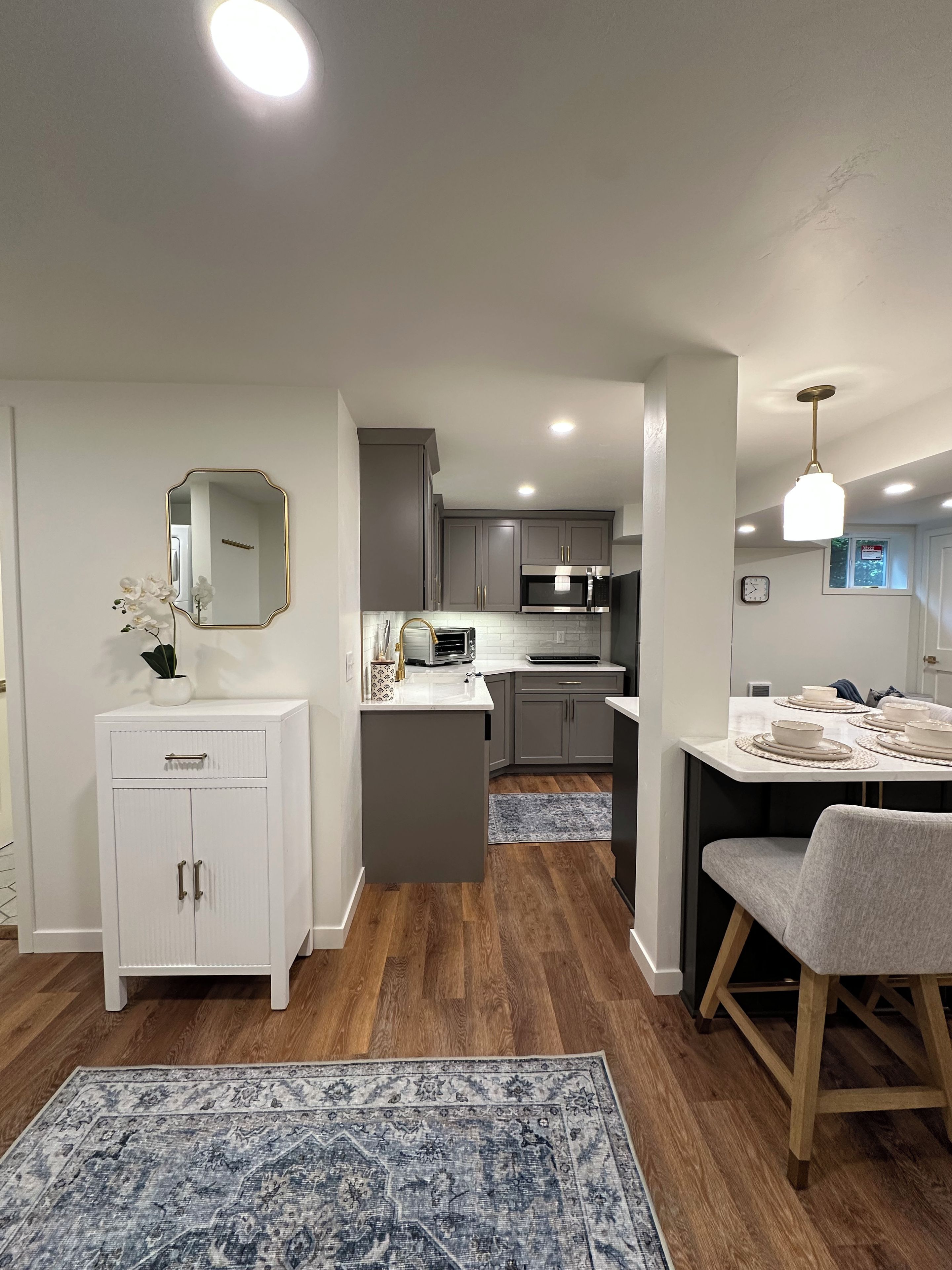A modern kitchen with grey cabinets, a white countertop, and a central island.