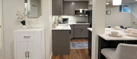 A modern kitchen with grey cabinets, a white countertop, and a central island.