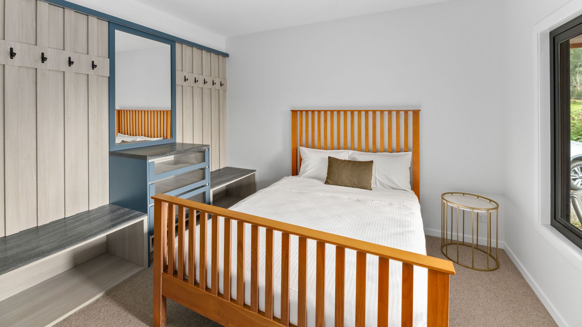 Un dormitorio con cama, cómoda, espejo y ventana.