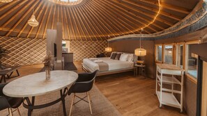 Una habitación acogedora con una cama, una mesa de comedor y un televisor.