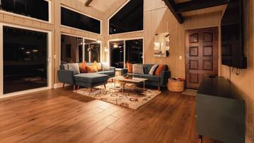 A spacious living room with a large sectional sofa, a coffee table, and a television on a stand.