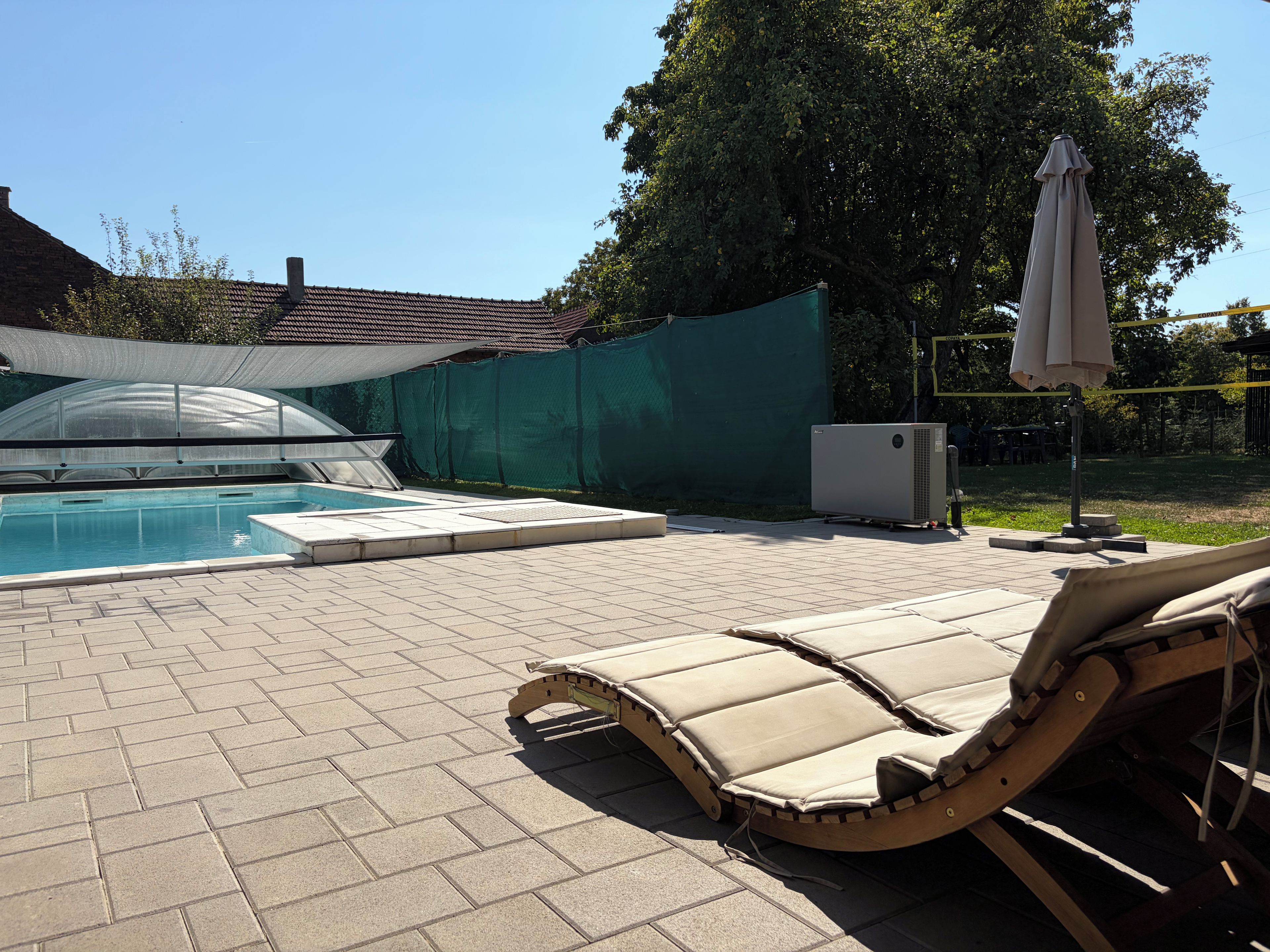 A swimming pool with lounge chairs and an air conditioning unit.