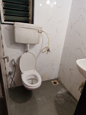 A bathroom with a toilet, a sink, and a shower. - Peaceful 1-bedroom apartment with AC in vibrant Thane (Thane)