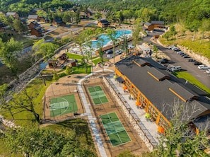 A resort with multiple tennis courts, a swimming pool, and a parking area. - 3-Level Luxury Cabin 🌲 Creek Views, Hot Tub & Top-Tier Resort Pools! (Hollister)