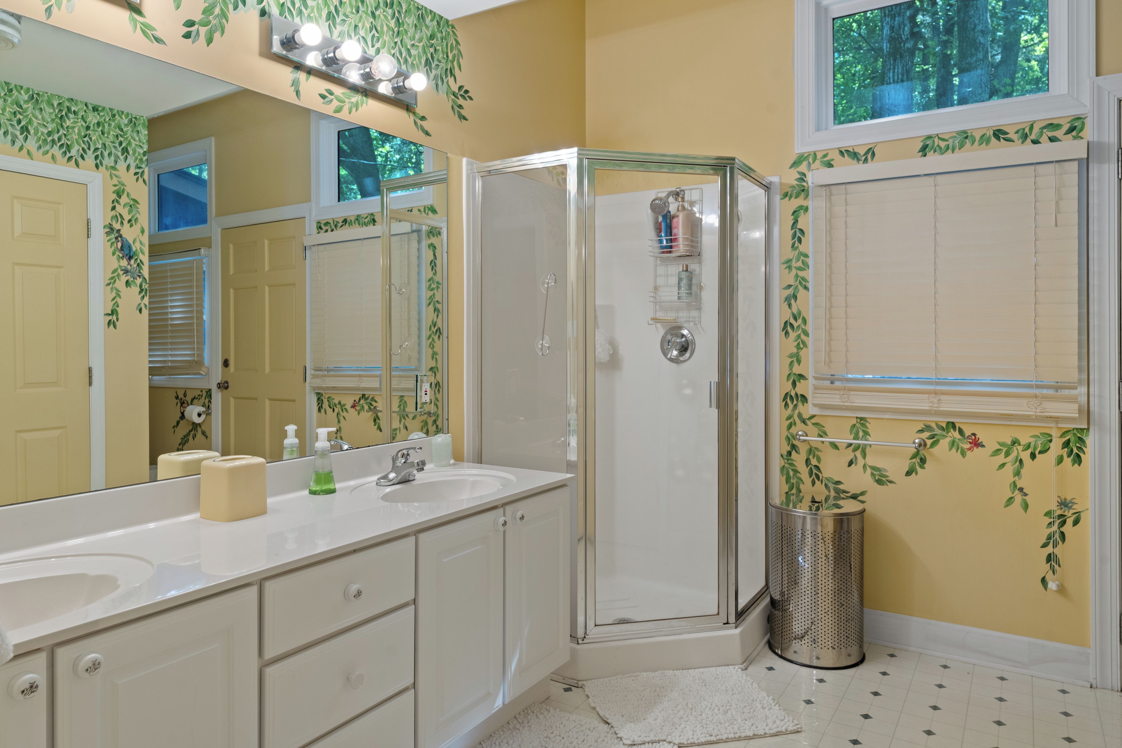 A bathroom with a shower, a sink, and a mirror.