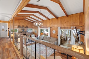 A spacious wooden interior with a high ceiling, a cozy seating area, and a view through a glass door. - Legacy Landing at Lake Guntersville (Guntersville)