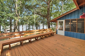 A wooden deck with a bench, overlooking a body of water with trees in the background. - Legacy Landing at Lake Guntersville (Guntersville)