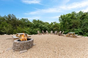 A circular outdoor seating area with a fire pit in the center, surrounded by Adirondack chairs and picnic tables. - Lakeview 3BR condo in Branson Cove with hot tub and pool access (Hollister)