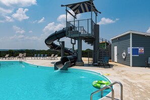 A swimming pool with a water slide, lounge chairs, and a lifeguard station. - Lakeview 3BR condo in Branson Cove with hot tub and pool access (Hollister)