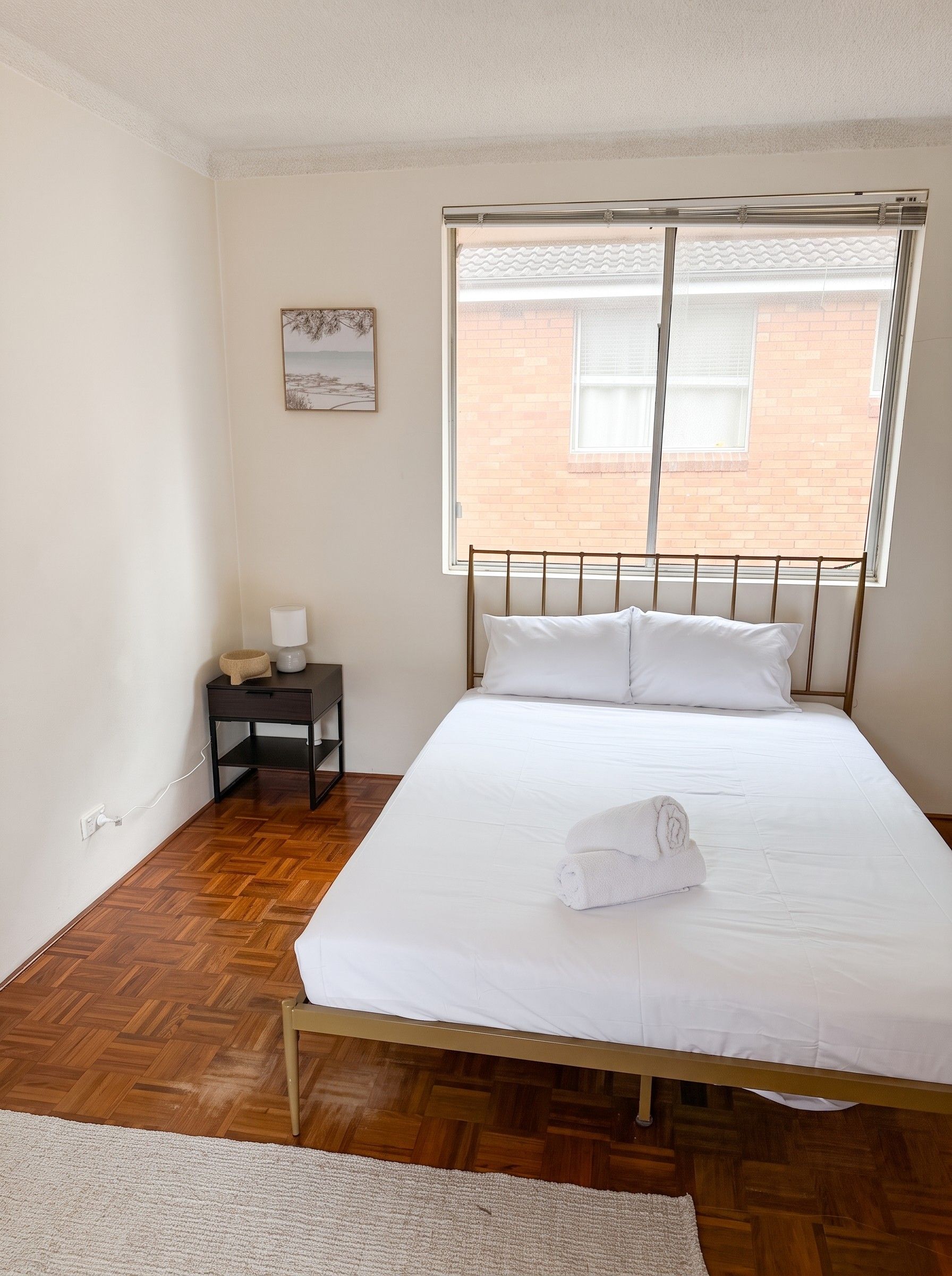 Queen bed made up with crisp white linen and fresh towels
