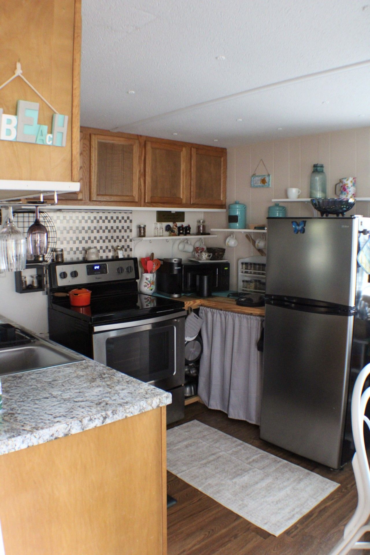 A kitchen with wooden cabinets, stainless steel appliances, and a granite countertop.