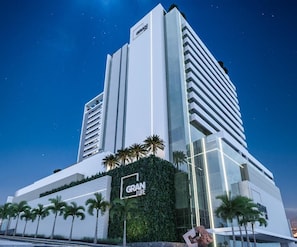Um hotel moderno com um grande letreiro 'GRAN LIFE', apresentando uma estrutura alta com vários andares e fachada de vidro.