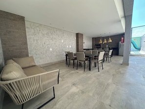 Um interior moderno com área de jantar, sofá e cozinha.