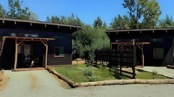 Un edificio con un área exterior techada, un sendero pavimentado y una valla de madera.