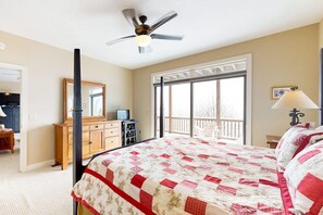 A bedroom with a bed, a ceiling fan, a dresser, a desk with a computer, and a window with a view. - Aerie Retreat | Mtn Views, Near Sugar Ski Resort (Sugar Mountain)