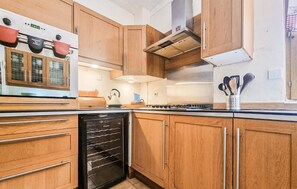 A kitchen with wooden cabinets, a dishwasher, a stove, and a kettle. - Lovely home in Carlux with heated swimming pool (Carlux)