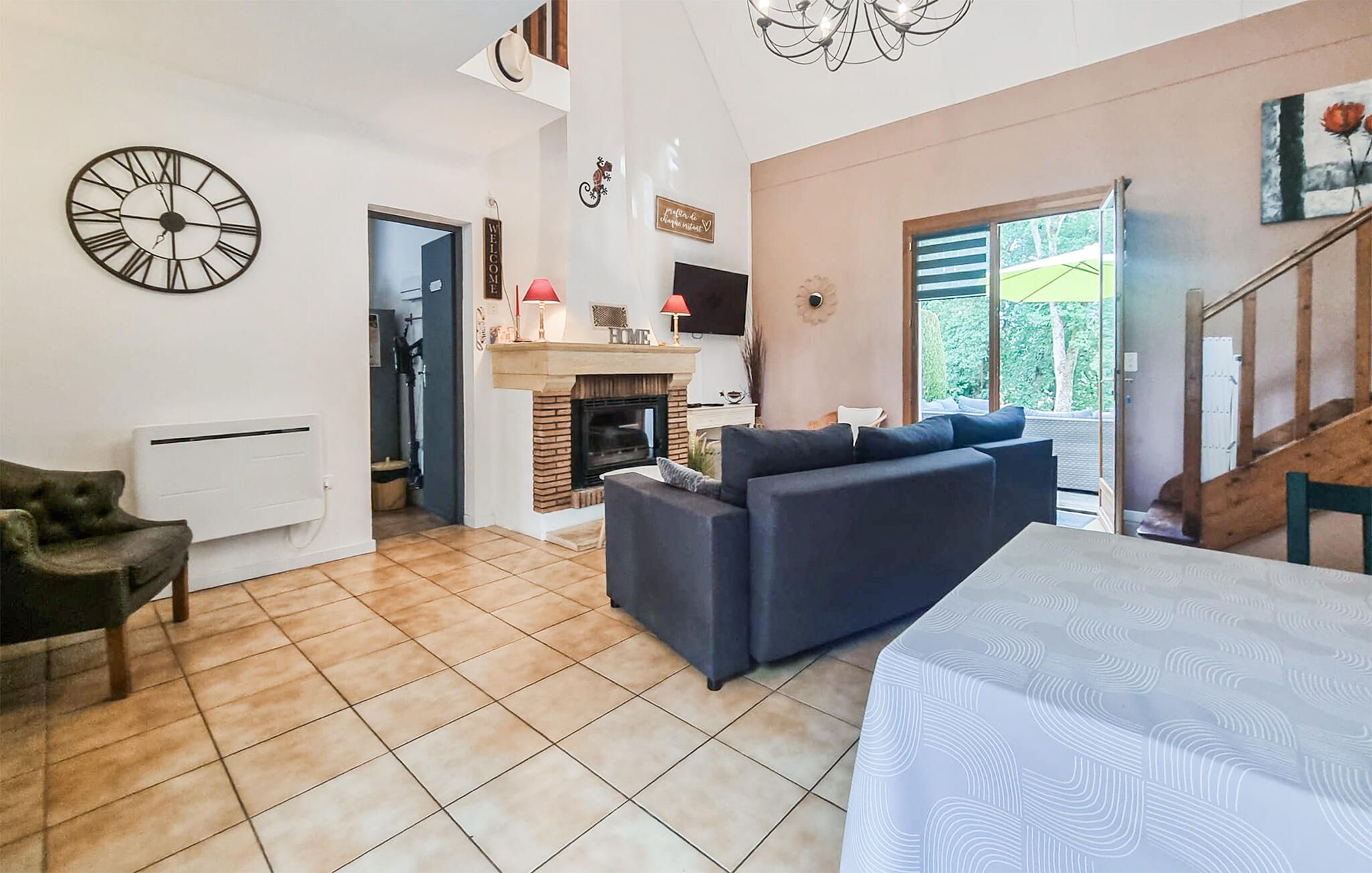 Una sala de estar moderna con chimenea, un sofá, una mesa de comedor y un reloj en la pared.
